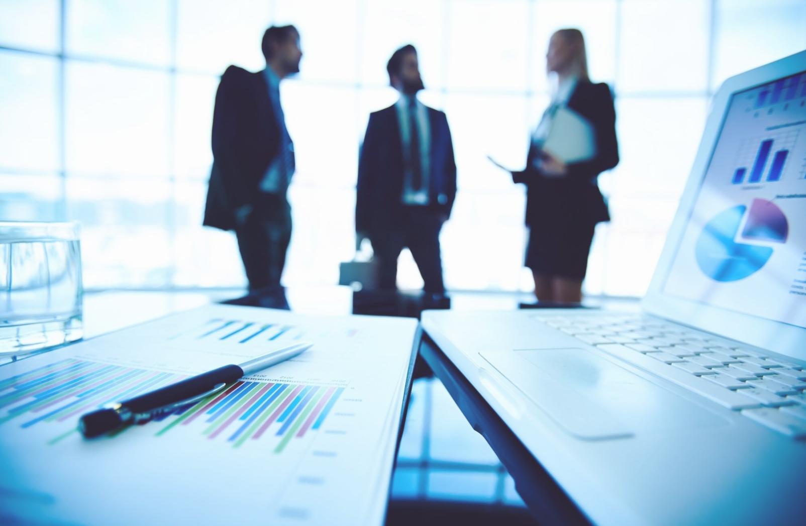 Modern office setup with multiple screens showing financial management software